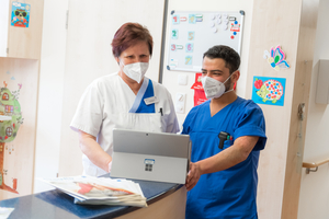 stationsleiterin beate krasselt und pfleger ahmed hebeshy im übnergabegesräch am stationstresen der kinderstation am sana klinikum borna